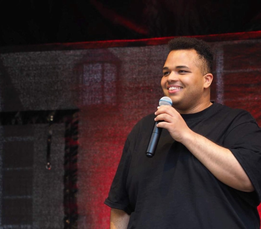 Oliver mit einem Mikrofon auf der Bühne